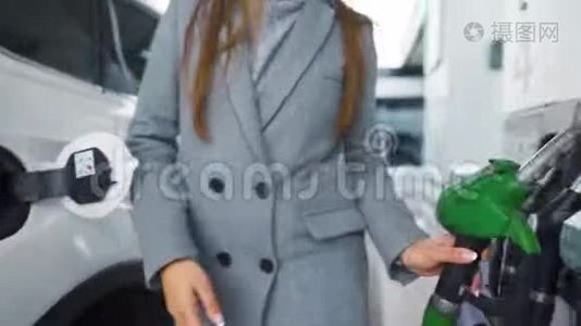 在加油站的一个特写镜头里，女人往她的车里灌汽油视频