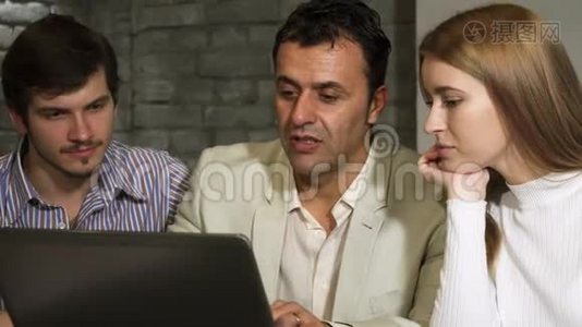 成熟的商人和他的年轻同事一起在笔记本电脑上工作视频