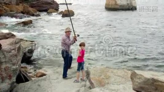 带小孩的老人把鱼竿扔到海里视频