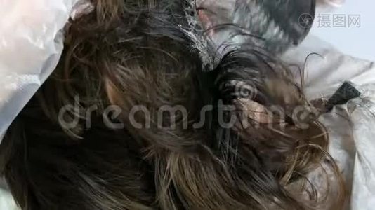 女性根上的白发，这种头发本身就是用特殊的油漆和刷子在家里染发的视频