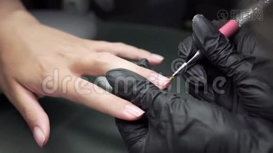 美甲师在美甲沙龙里对女孩的指甲进行修脚和延长指甲的程序视频