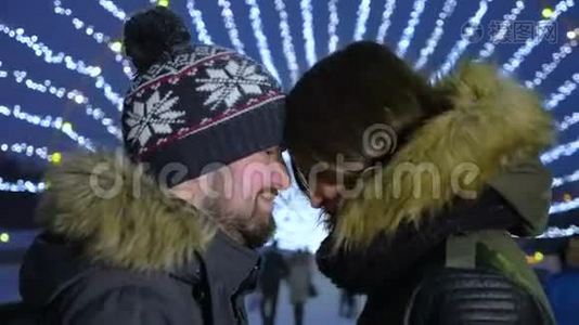快乐浪漫的情侣拥抱在圣诞城街道。 慢动作。视频