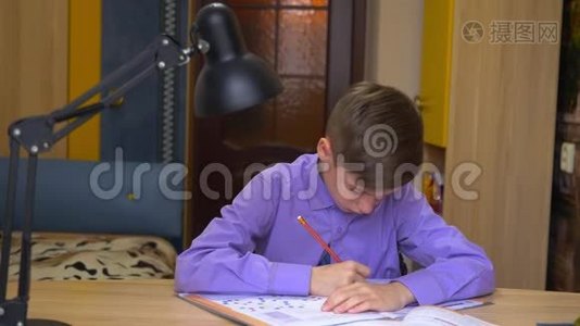 一个十几岁的男孩做家庭作业。 远程教育。 家庭教育视频
