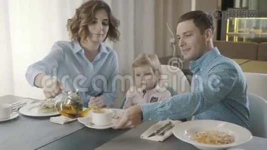 一家餐馆里有个小孩的家庭：爸爸、妈妈和女儿视频