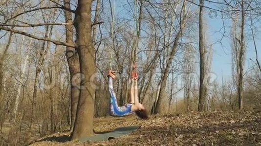 这名女子在训练气引力时，挂在树上的绳子上视频