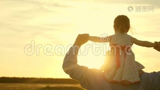 父亲带着女儿走在夕阳下的肩膀上。 爸爸背着心爱的孩子视频