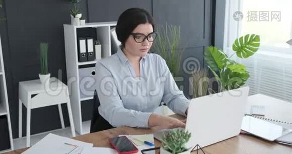 女商人用手提电脑和手机聊天视频