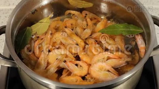 用平底锅煮虾。 在烹饪过程中搅拌虾。视频