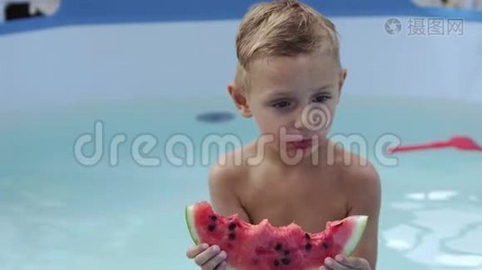 戴黑眼镜的男孩在游泳池里吃西瓜视频