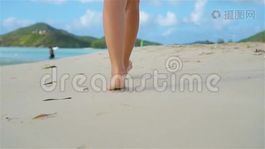 在日落时分，在海岸上赤脚行走的女性的双脚。 动作缓慢。视频