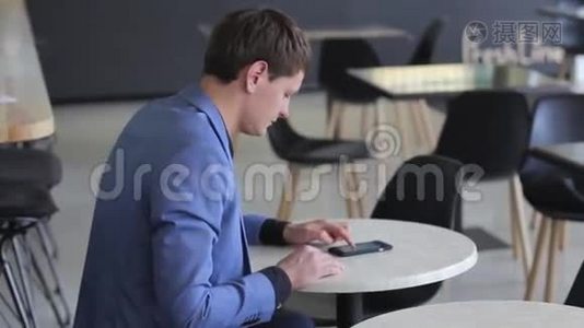 一个年轻人在咖啡馆里用他的移动设备视频