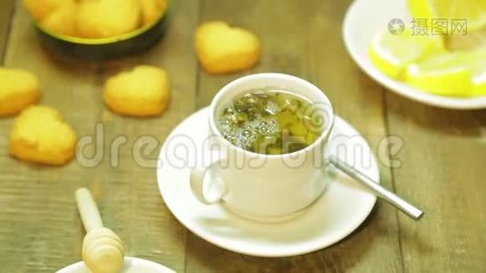 在木桌上的白色杯子里新鲜冲泡的绿茶视频