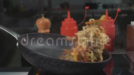厨师薯条面条，各种蔬菜和肉在热炒锅上视频