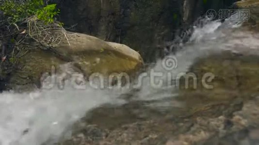 湍急的河流在热带森林中流淌.. 大石头上的瀑布流出来的河水。视频