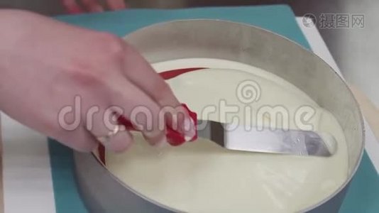 在转盘上用烤制的奶油上的糖霜刮刀制作女性糖果视频