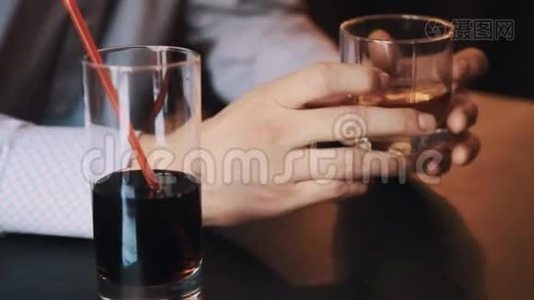 穿格子衬衫的人手拿着一杯威士忌在咖啡馆的桌子上视频