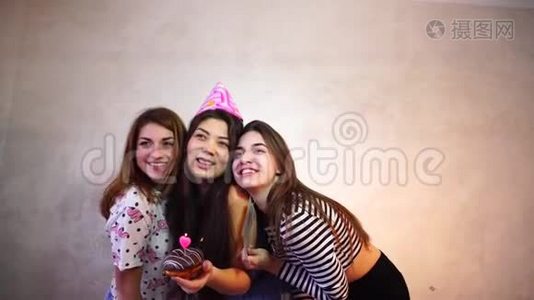 可爱友好的女孩庆祝她们的女性朋友的生日，并在灯光墙的背景下玩得开心。视频