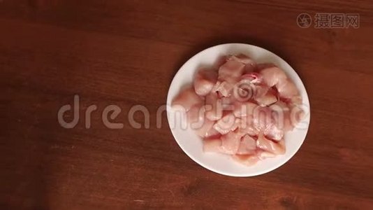 在白色盘子上特写生鸡肉。视频