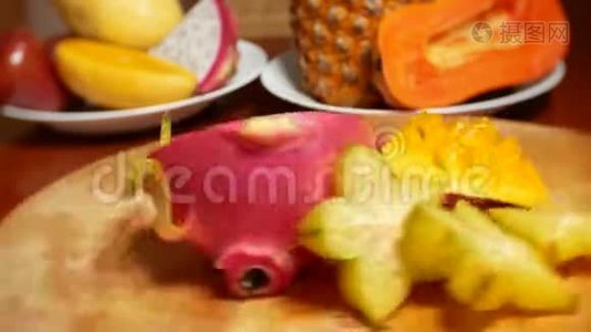餐桌上的异国水果。 采购产品4k，杨桃和龙果，木瓜，芒果，芒果和龙眼，西番莲，水果视频
