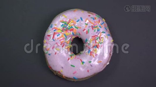 美味新鲜的甜甜圈特写镜头旋转在黑色背景。视频