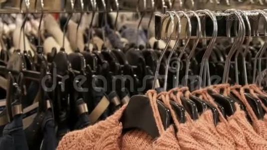 服装店购物中心衣架上挂着大量不同颜色的新款保暖时尚毛衣视频