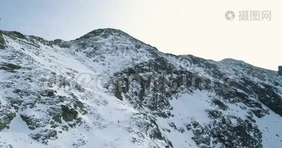 冬天的雪山上，空中落后，登山滑雪者向上攀登。雪覆盖着群山视频