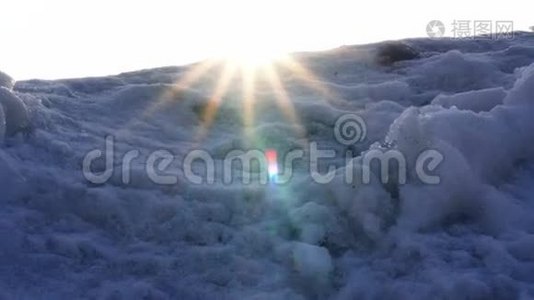 温暖的阳光透过摄像机镜头中覆盖着寒冷的雪山视频