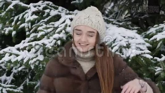 一块雪落在站在树旁的女孩身上。 慢动作视频