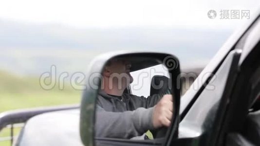 男人手拿麦克风，在车里用收音机说话。视频
