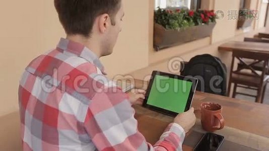男士手持平板电脑触摸屏，带有用于定制内容的绿屏色度键。男士饮料可与绿屏搭配使用。视频