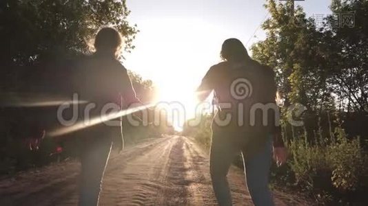儿童旅行者。 徒步旅行者女孩。 带着背包的快乐女孩旅行者牵着双手在乡间小路上奔跑视频