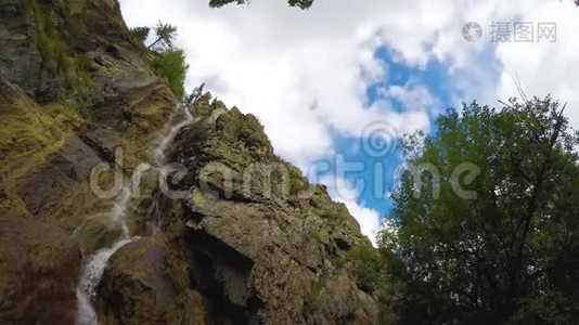 蓝色天空中的岩石中的漩涡瀑布，白云背景。 时间流逝4K，阿尔泰山视频