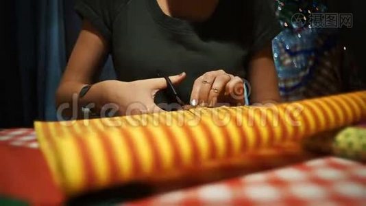 女性切割黄色与橙色条纹包装纸包装礼物视频