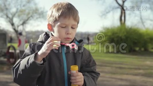 这个男孩在玩肥皂泡。 小男孩吹泡泡视频