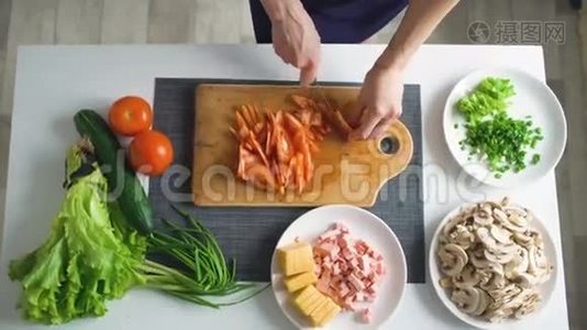 厨房里的披萨晚餐，女人用手在木板上切菜的俯视图视频