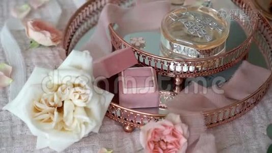 女人把珠宝戒指放在粉红色托盘的盒子里，上面有新娘耳环、求婚戒指和香水视频