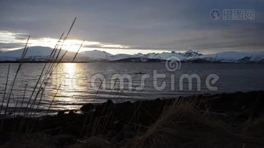 在雪山岛上的景色和北极圈峡湾表面的五颜六色的倒影上，深深的、生机勃勃的日落视频