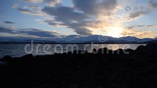 在雪山岛上的景色和北极圈峡湾表面的五颜六色的倒影上，深深的、生机勃勃的日落视频