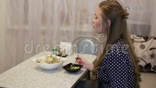 年轻漂亮的女孩在房子的客厅吃晚饭。视频