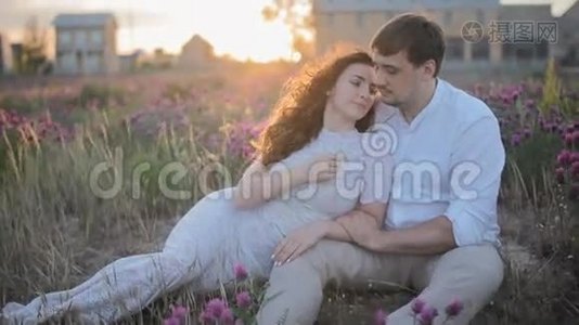 年轻的白种人夫妇坐在田野里视频