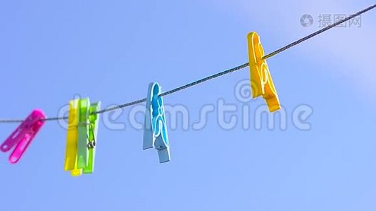 彩色衣夹在晾衣绳上，迎风蓝天。视频