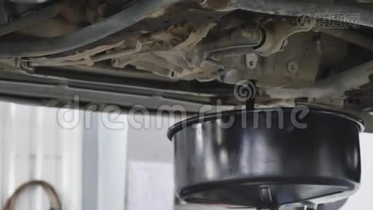 汽车修理工在汽车换油期间从汽车上抽出机油视频