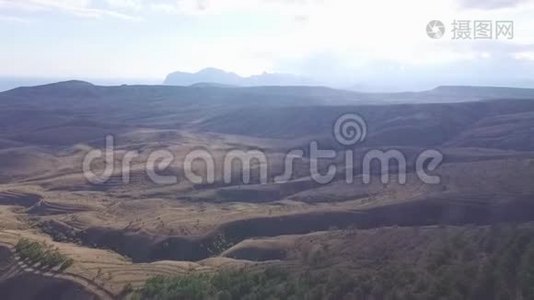 从山顶、自然小径、树木和植物的山、植被、天空和云的背景鸟瞰视频