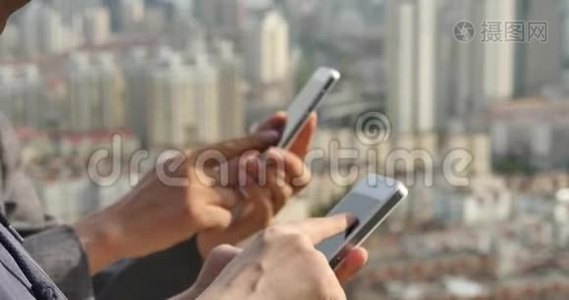 人类使用智能手机的现代城市建筑背景。视频