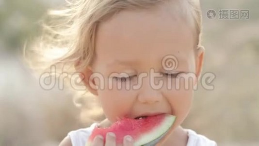 日出时小可爱小女孩吃红西瓜的特写镜头视频
