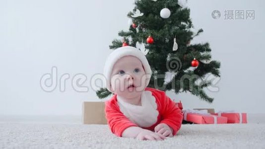 可爱的宝宝穿着圣诞老人的服装，看着视频