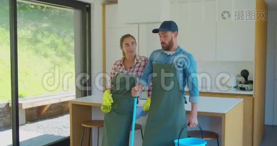 一对疲惫的夫妇在厨房休息时站在一个穿制服的职业清洁工的画像。视频