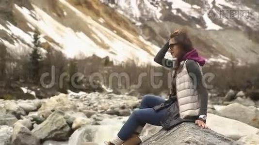 一位年轻女子坐在群山的背景上视频