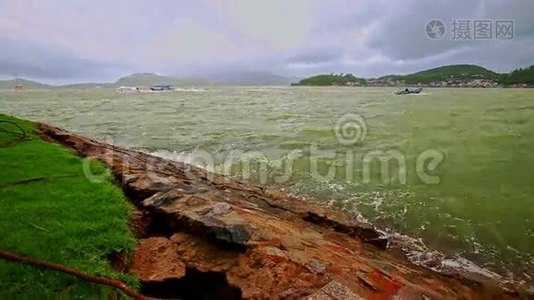 在多云的天空下，岩石岸的碧波荡漾视频