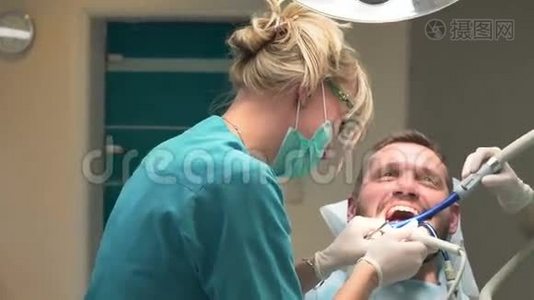 牙医和助手从牙齿上移除牙石。 斯坦迪卡姆。视频